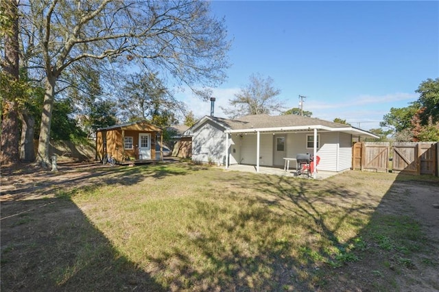 back of house featuring a yard, a shed, and a patio area