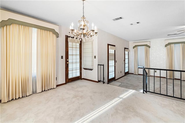 carpeted foyer with ceiling fan with notable chandelier