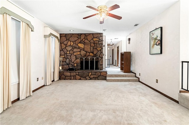 unfurnished living room featuring ceiling fan, a fireplace, and light colored carpet