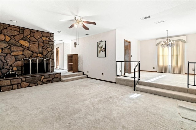 unfurnished living room featuring a stone fireplace, light colored carpet, and ceiling fan with notable chandelier