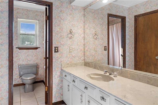 bathroom with toilet, vanity, and tile patterned floors