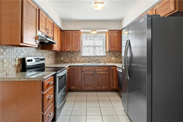 kitchen with sink, light stone countertops, a textured ceiling, light tile patterned flooring, and stainless steel appliances