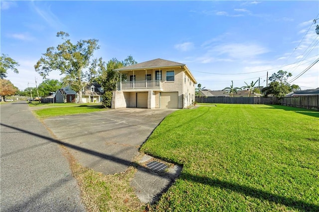 view of front of home featuring a garage, a balcony, and a front lawn