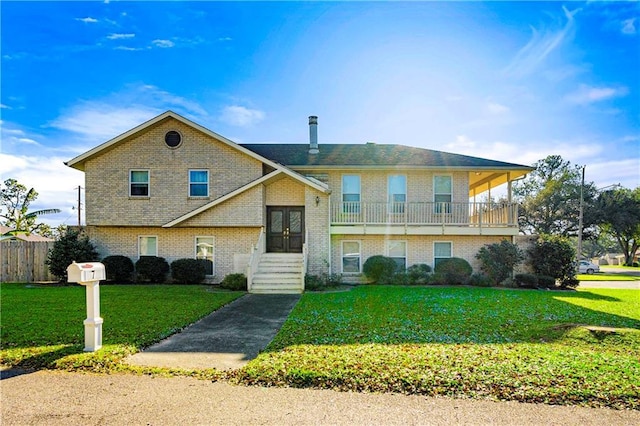 split foyer home with a balcony, french doors, and a front lawn