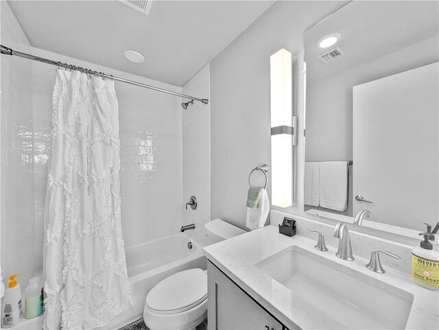 full bathroom featuring toilet, vanity, and shower / tub combo with curtain