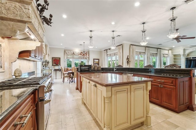 kitchen featuring pendant lighting, stainless steel stove, ceiling fan, and a spacious island