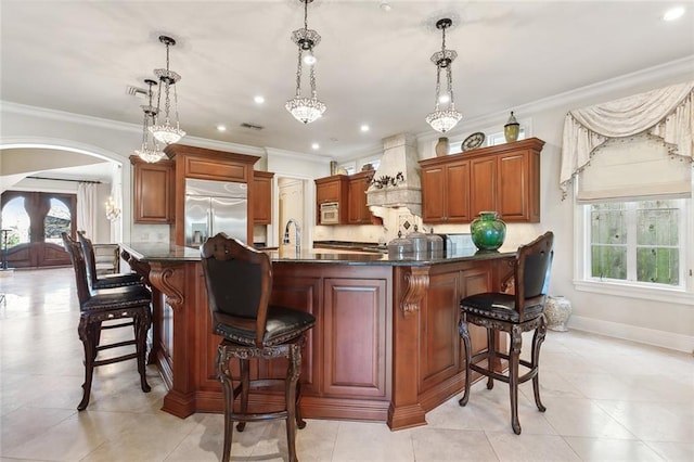 bar with built in fridge, decorative light fixtures, crown molding, and premium range hood