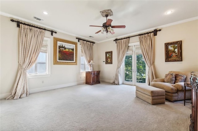 sitting room featuring ceiling fan, light colored carpet, and crown molding