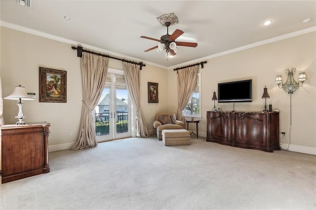 living area with light colored carpet, ceiling fan, and crown molding