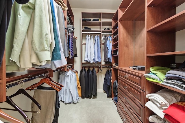 walk in closet featuring light colored carpet