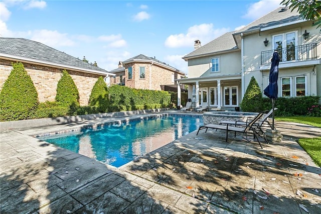 view of swimming pool with french doors and a patio