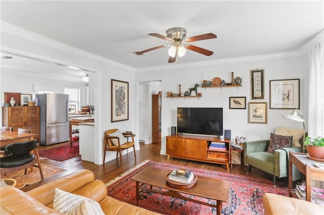 living room featuring dark hardwood / wood-style floors, ceiling fan, and crown molding