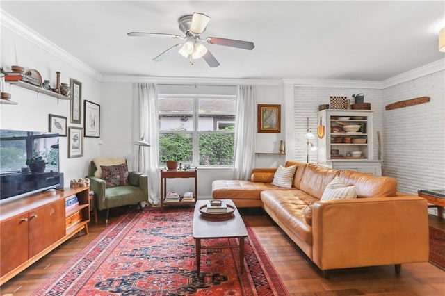 living room featuring crown molding, ceiling fan, and brick wall