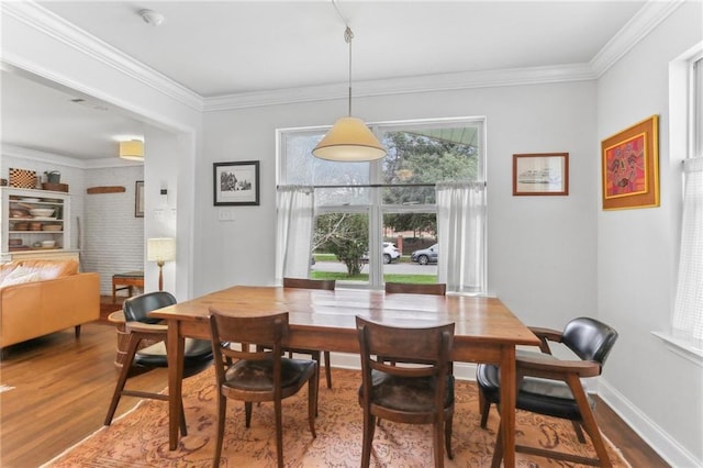 dining space with wood-type flooring and crown molding