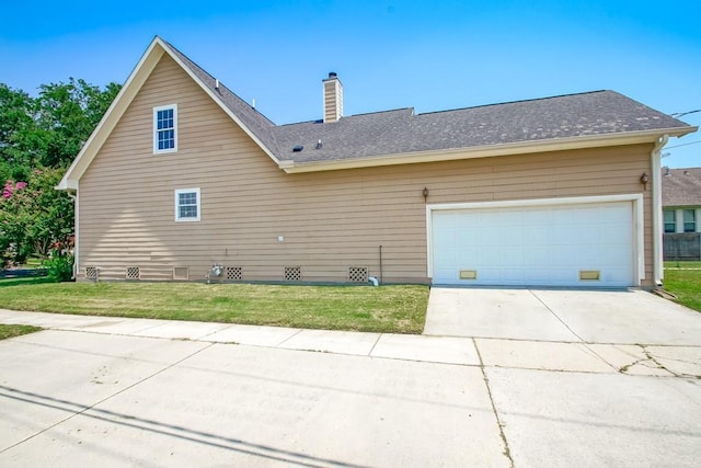 view of side of home with a yard and a garage