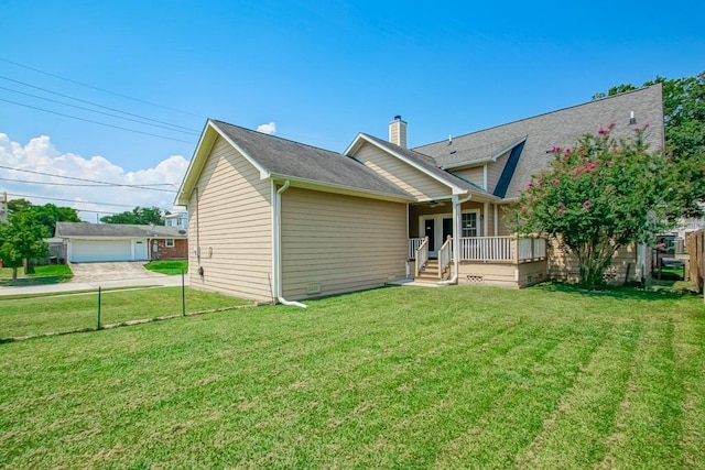 rear view of house with a porch and a yard