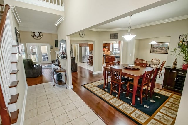 dining area featuring light tile patterned floors, crown molding, and french doors