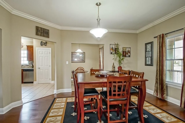 dining area featuring crown molding and light wood-type flooring