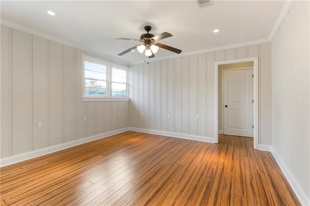 spare room featuring ceiling fan, light wood-type flooring, and crown molding