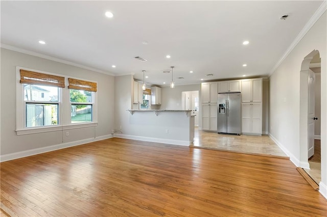 unfurnished living room with light wood-type flooring and ornamental molding