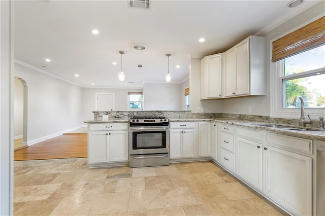 kitchen with white cabinets, sink, stainless steel range, decorative light fixtures, and light stone counters