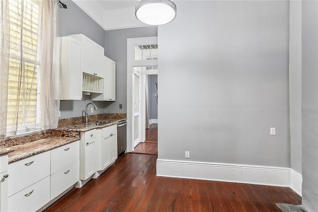 kitchen with dark wood-type flooring, a sink, white cabinetry, light stone countertops, and dishwasher