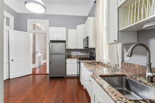 kitchen featuring dark wood-type flooring, a sink, light stone counters, white cabinetry, and appliances with stainless steel finishes