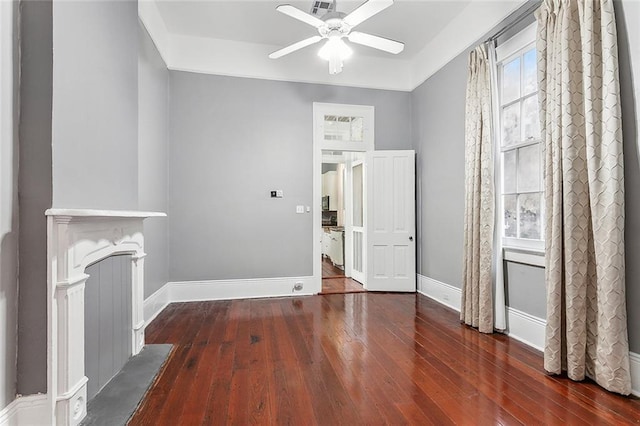 unfurnished living room with baseboards, a ceiling fan, and hardwood / wood-style flooring