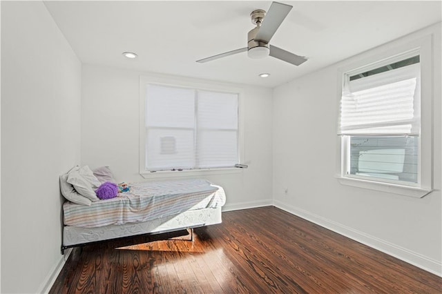 bedroom with multiple windows, ceiling fan, and dark hardwood / wood-style floors