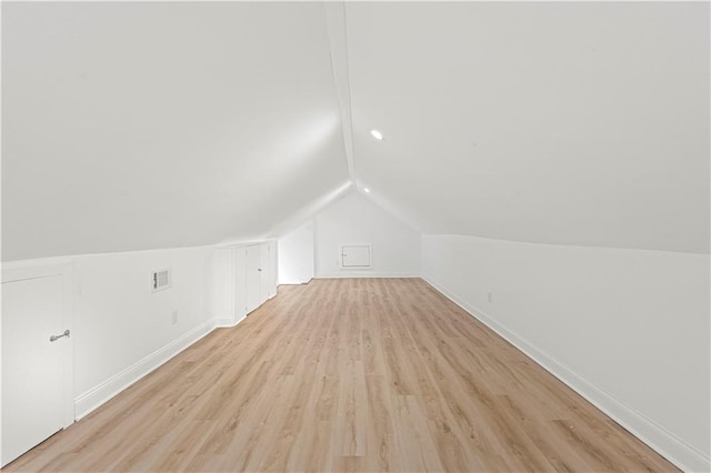 additional living space with light wood-type flooring and lofted ceiling