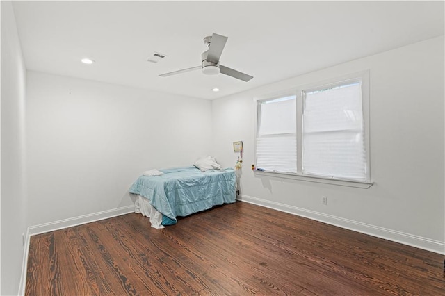 unfurnished bedroom with ceiling fan and dark wood-type flooring