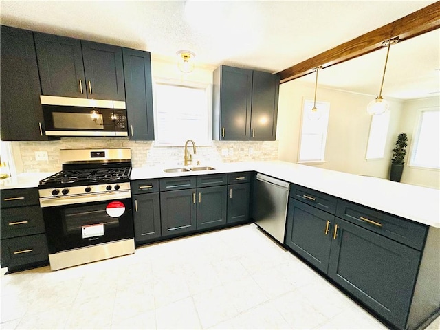 kitchen featuring sink, hanging light fixtures, stainless steel appliances, tasteful backsplash, and kitchen peninsula