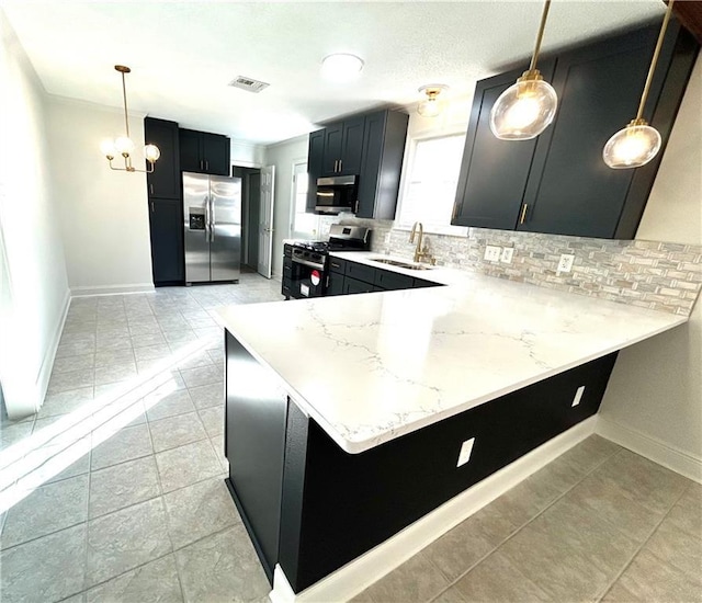 kitchen with kitchen peninsula, appliances with stainless steel finishes, decorative light fixtures, and sink