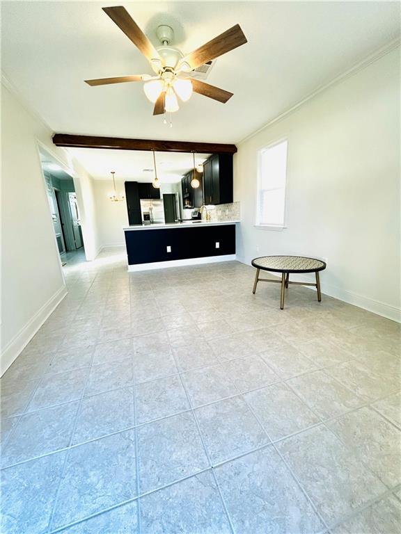 unfurnished living room with beam ceiling, ceiling fan, and crown molding