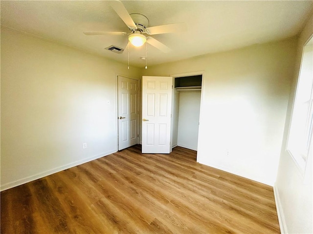 unfurnished bedroom with ceiling fan, a closet, and hardwood / wood-style flooring