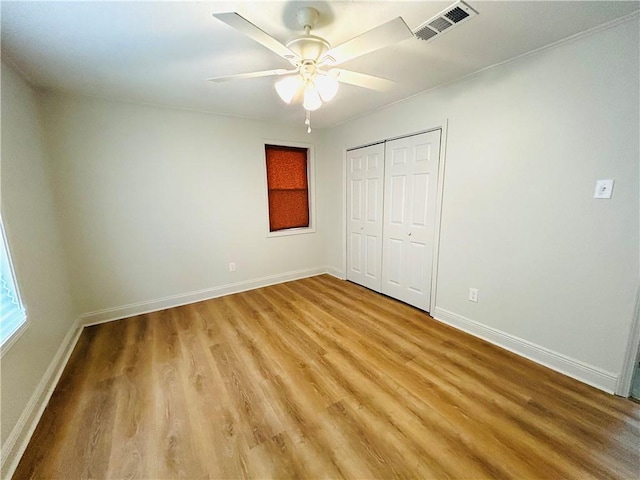 unfurnished bedroom featuring wood-type flooring, a closet, and ceiling fan