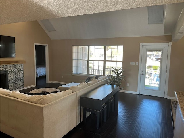 living room with a textured ceiling, dark wood-type flooring, and lofted ceiling