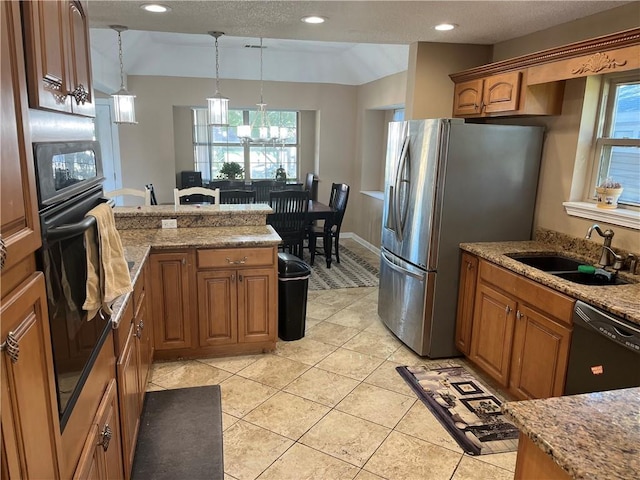 kitchen featuring black appliances, sink, decorative light fixtures, light tile patterned flooring, and light stone counters