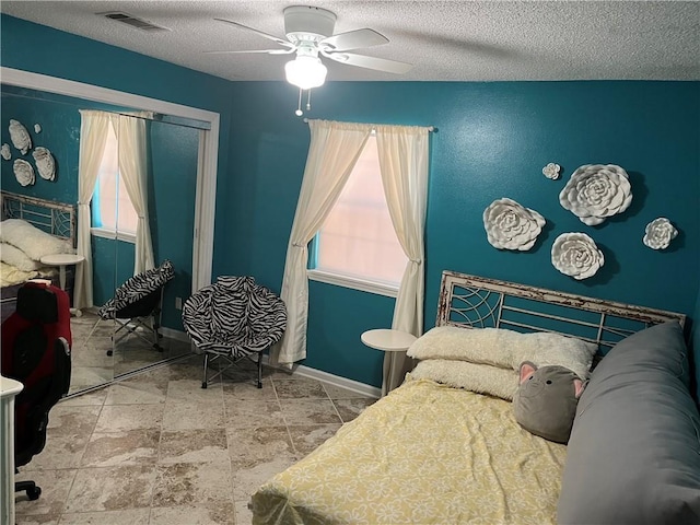 bedroom featuring a textured ceiling and ceiling fan