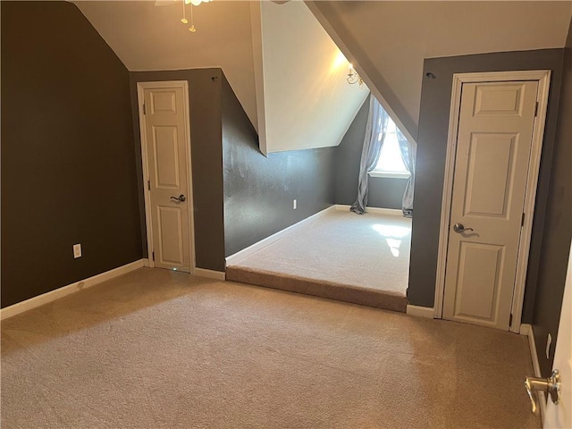 bonus room featuring ceiling fan, lofted ceiling, and light carpet