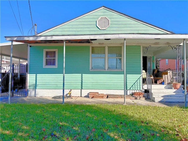 rear view of house featuring a yard