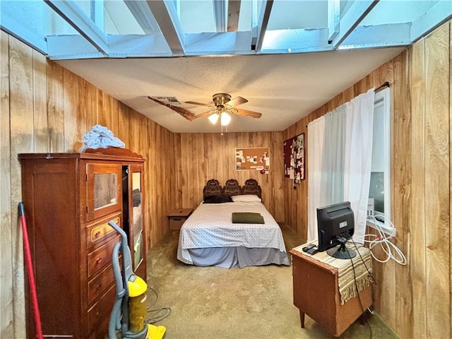 carpeted bedroom featuring a skylight and wood walls