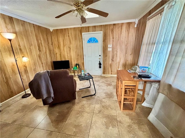 living room with ceiling fan, ornamental molding, and wooden walls