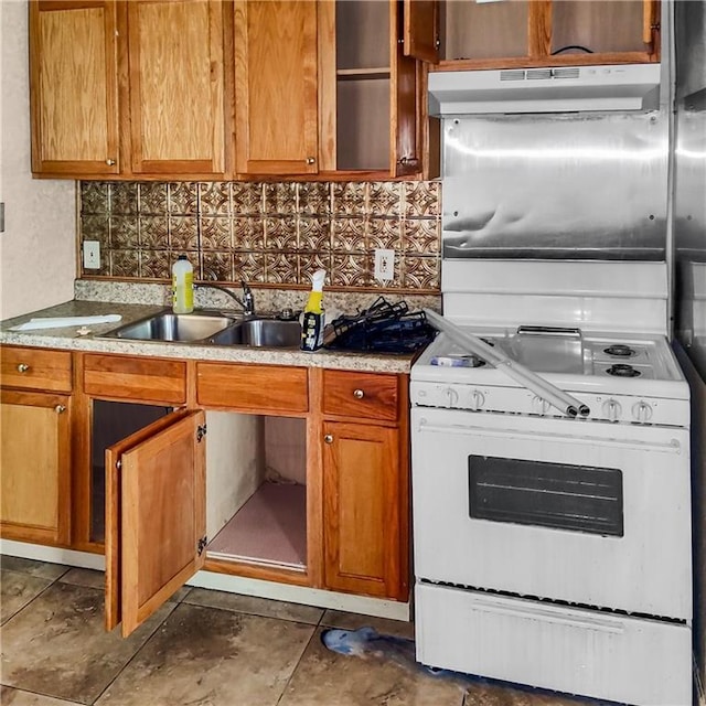 kitchen featuring backsplash, sink, and white stove