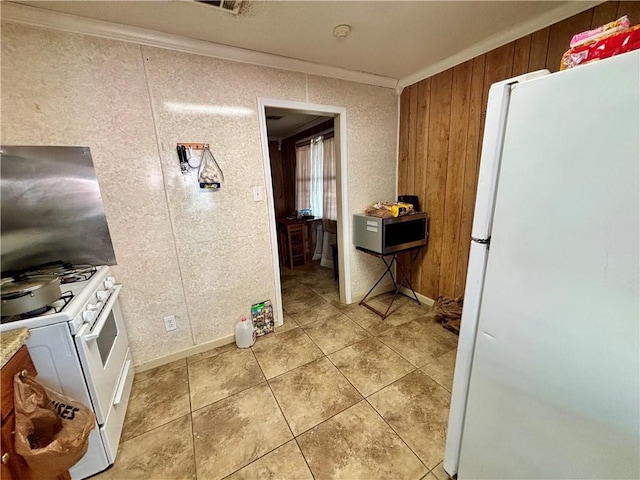 kitchen with crown molding, light tile patterned flooring, and white appliances