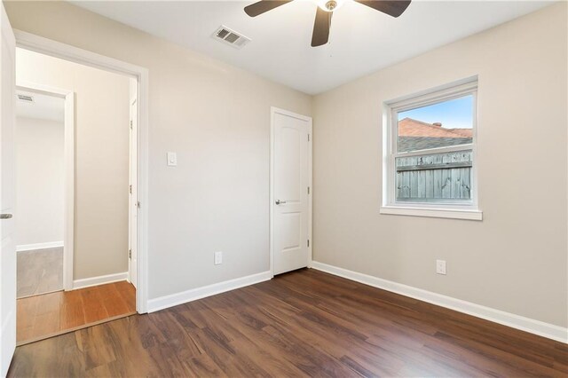 spare room featuring ceiling fan and dark wood-type flooring