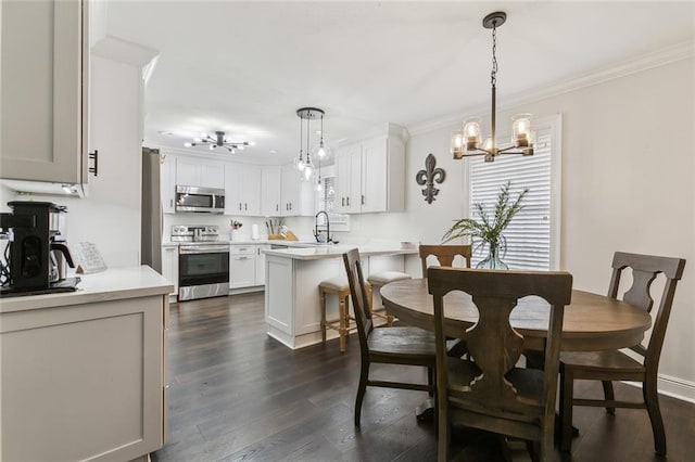 dining area featuring dark hardwood / wood-style floors, an inviting chandelier, crown molding, and sink