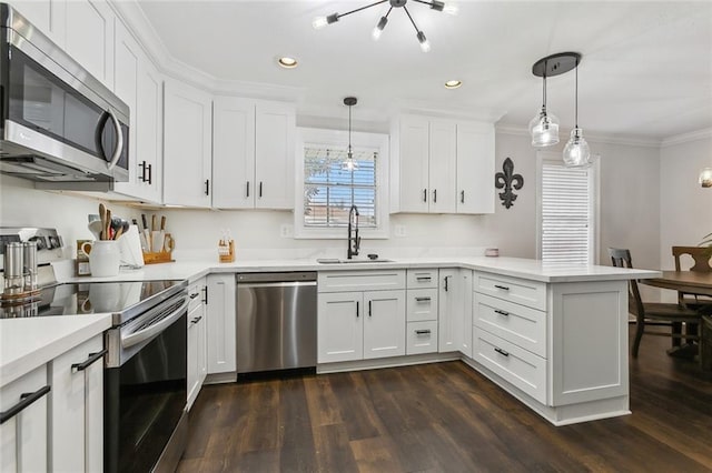 kitchen featuring decorative light fixtures, sink, kitchen peninsula, and stainless steel appliances