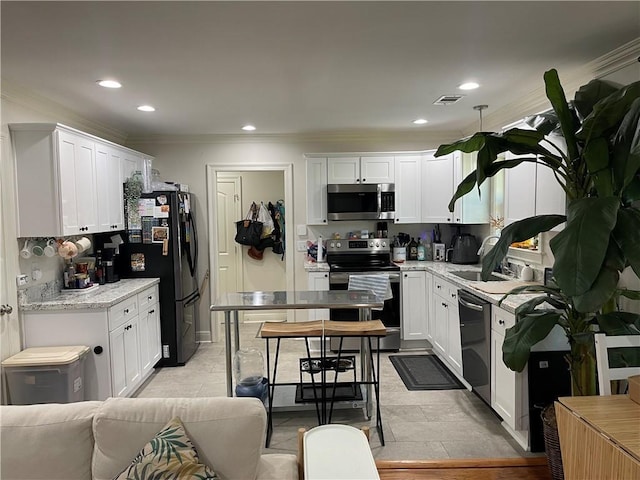 kitchen featuring white cabinetry, sink, crown molding, light tile patterned flooring, and appliances with stainless steel finishes