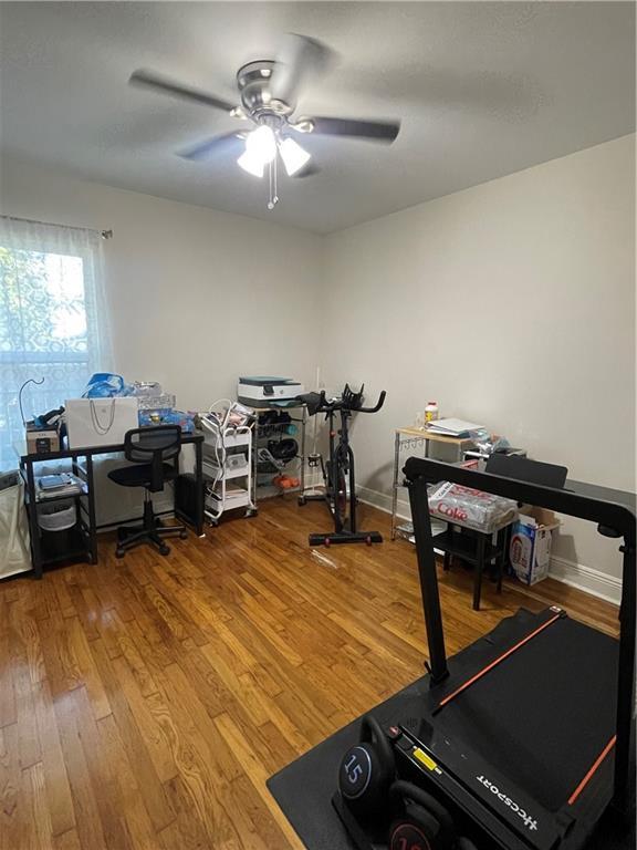 workout area featuring ceiling fan and hardwood / wood-style floors